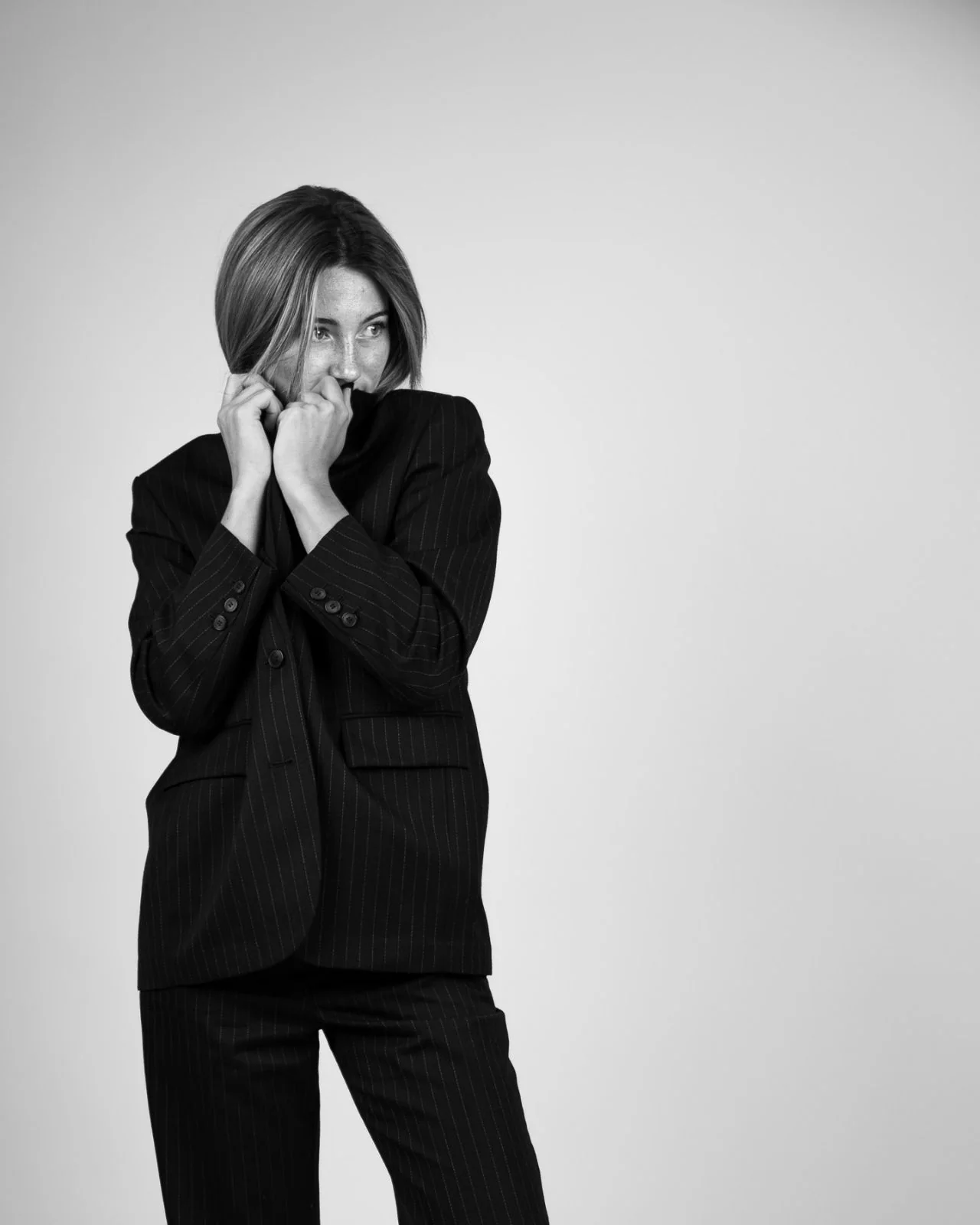 Portrait mode en studio, costume à fines rayures sur fond clair